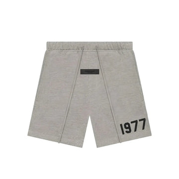 Fear of God Essentials 1977 Dark Oatmeal sweatshort with black drawstring and "1977" graphic.