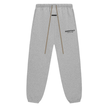 Fear of God Essentials Light Heather Grey fleece sweatpants with black logo and brown drawstrings.