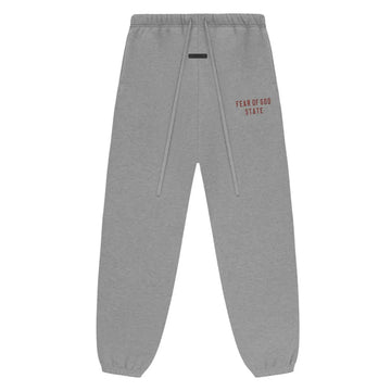 Fear of God Essentials Dark Heather fleece sweatpants with "FEAR OF GOD STATE" in red text.