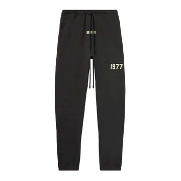 Fear of God Essentials 1977 Iron Sweatpant, minimalistyczne spodnie z białym nadrukiem "1977" i sznurkiem.